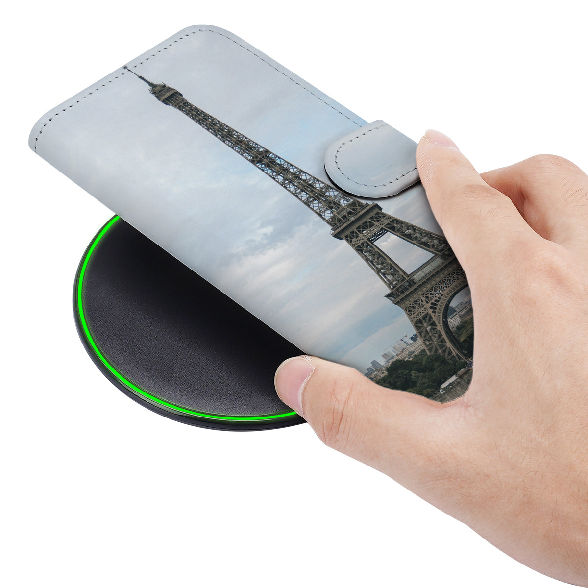 Hand houdt de gesloten Galaxy S24 Plus bookcase met de Eiffeltoren schuin van opzij vast
