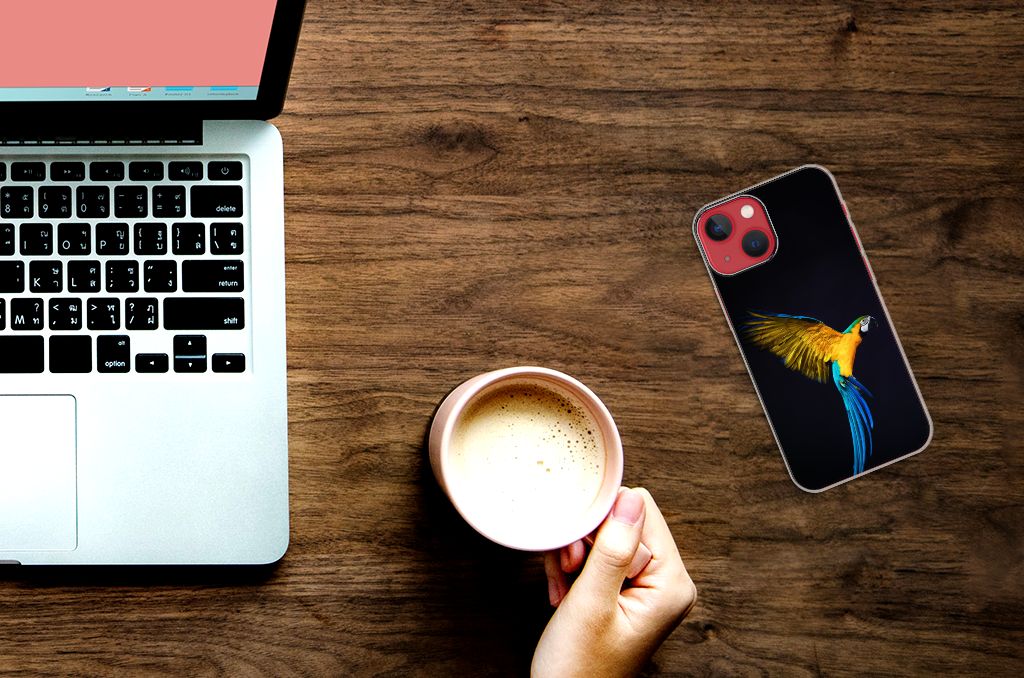 Apple iPhone 13 TPU Hoesje Papegaai met kleurrijke papegaai op zwarte achtergrond naast een laptop en een koffiemok.