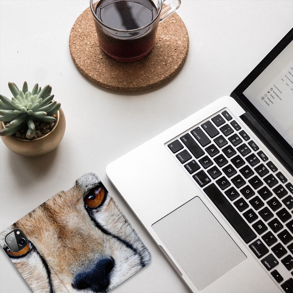 Apple iPhone 14 Plus Hoesje maken Cheetah met close-up van een cheetah naast een laptop en een plantenpot.