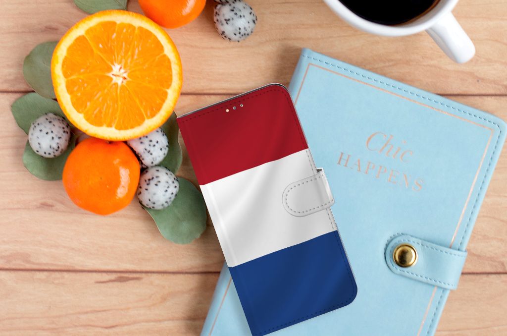 OPPO A15 Bookstyle Case Nederlandse Vlag naast een notitieboek en fruit op een houten tafel.