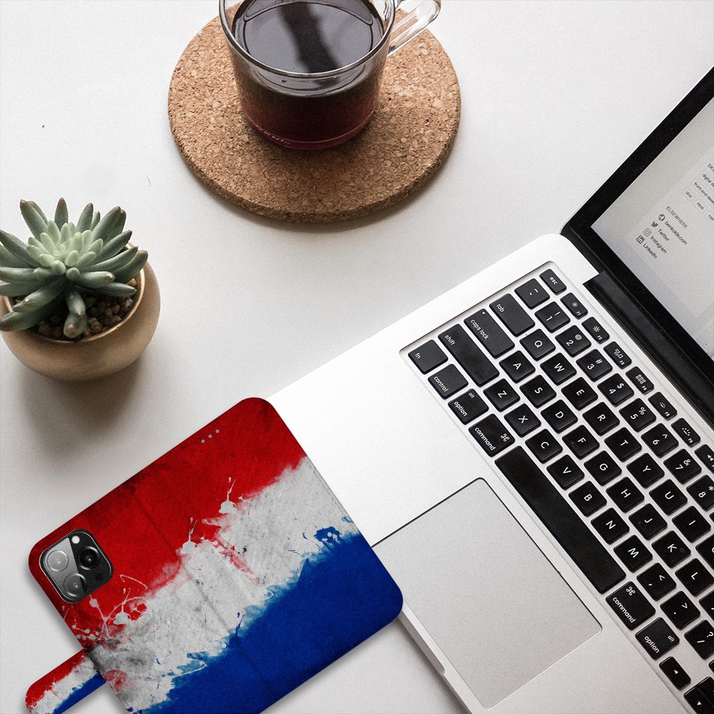 iPhone 13 Pro Max Bookstyle Case Nederland met artistieke Nederlandse vlag op bureau met laptop en koffie