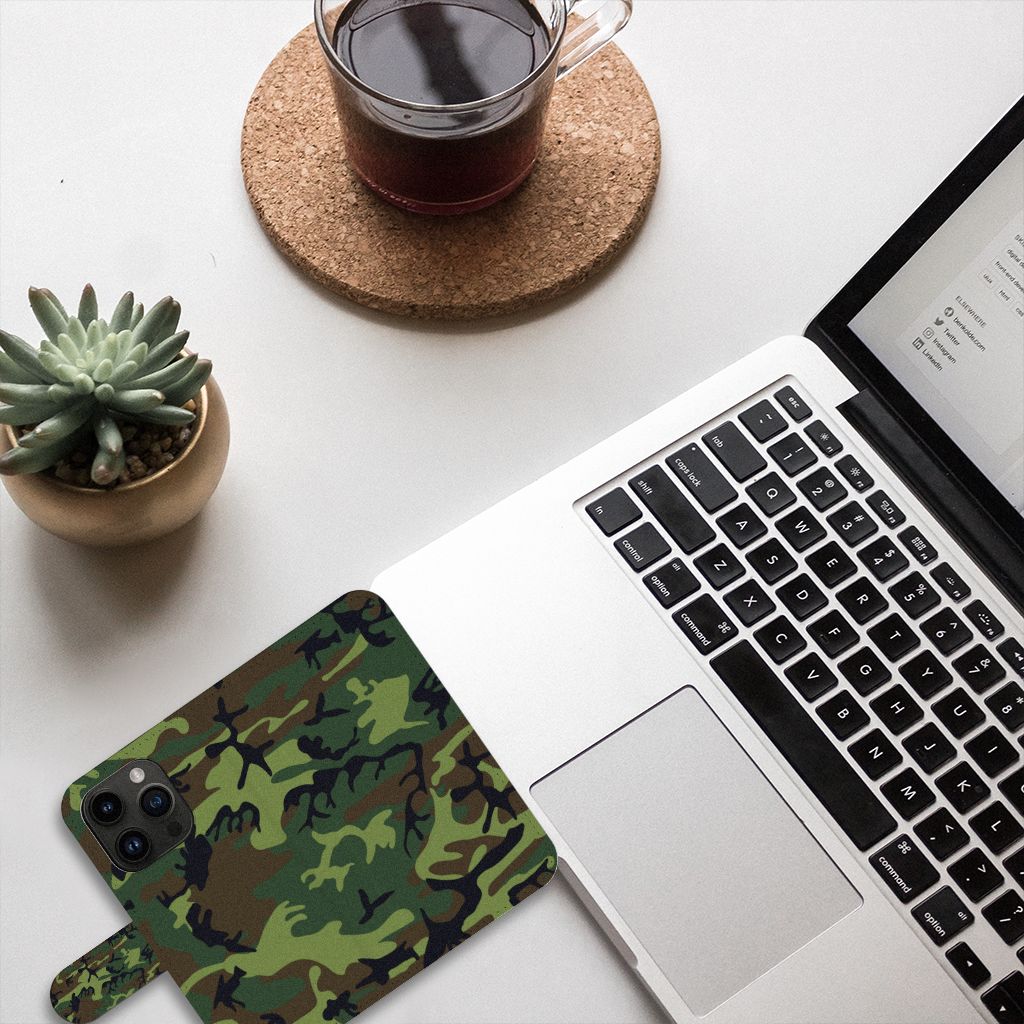 iPhone 15 Pro Telefoon Hoesje Army Dark op bureau met laptop en koffie, stijlvol camouflagedesign.
