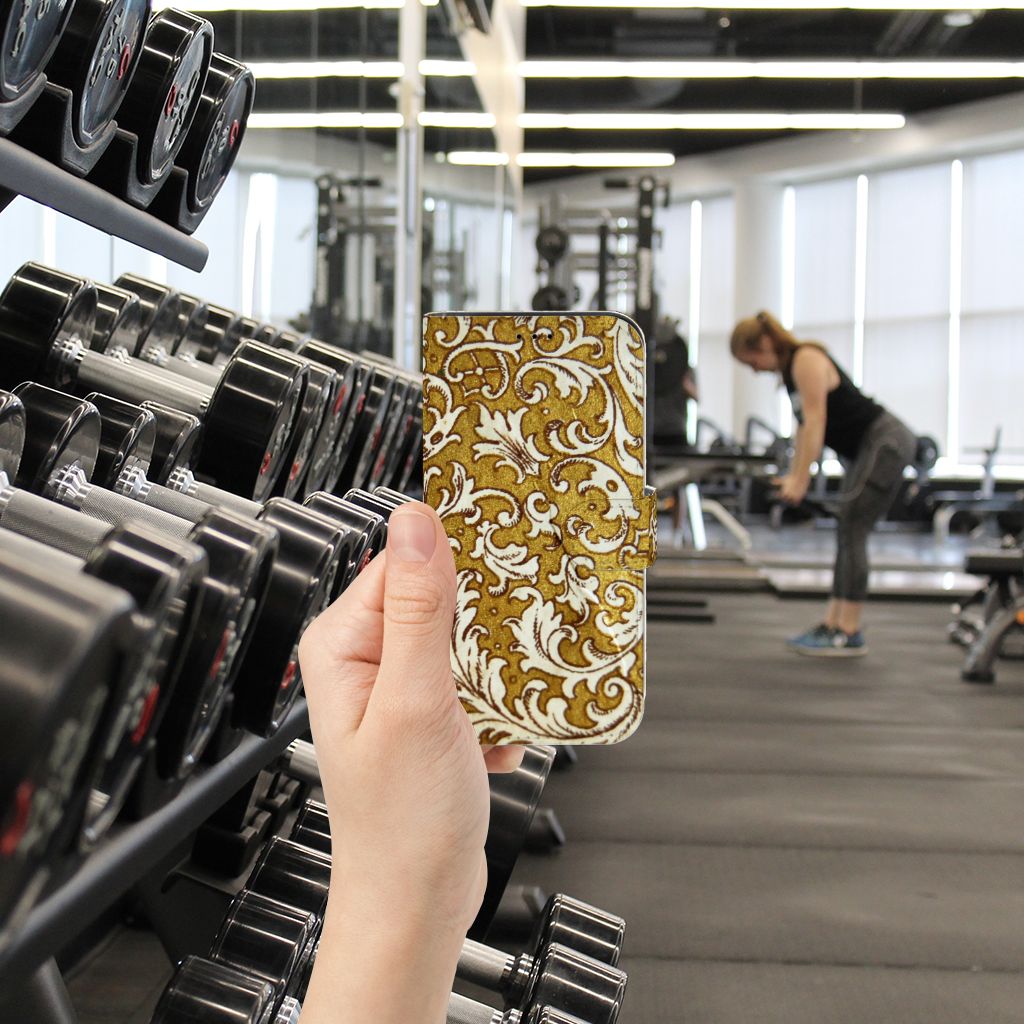 Wallet Case iPhone 13 Pro Barok Goud met gouden barok design in een sportschoolomgeving.