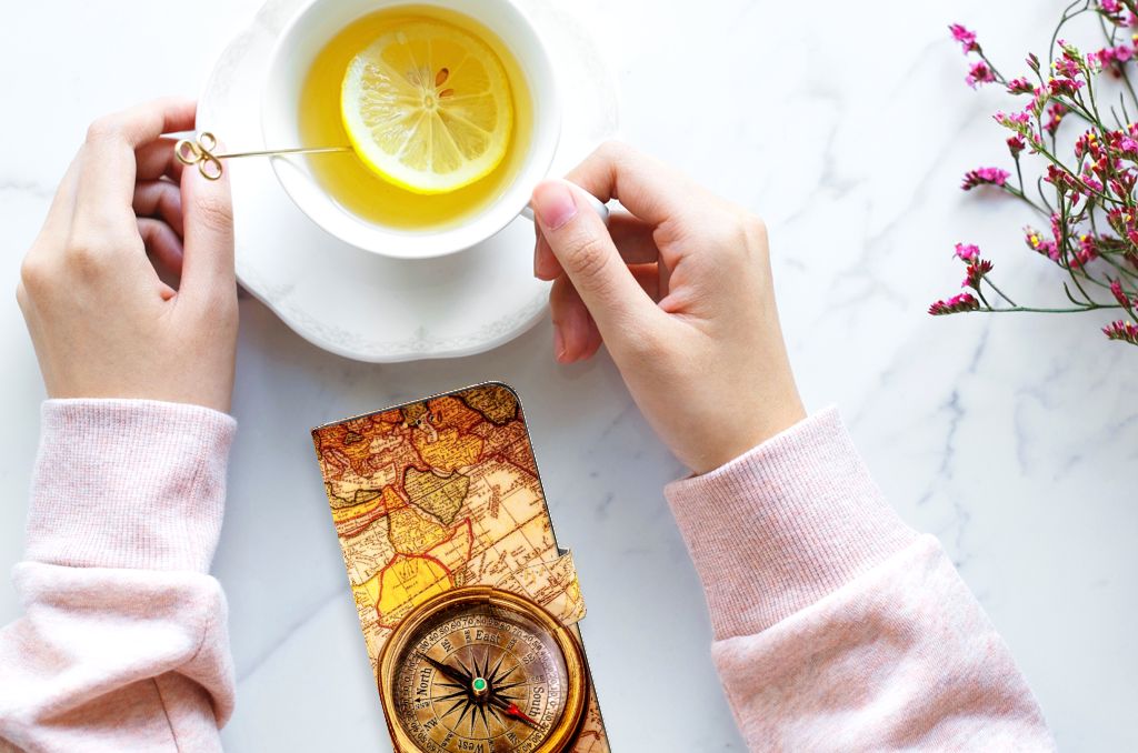 Samsung Galaxy A14 5G Flip Cover Kompas met kompas en een kop met thee op een marmeren tafel.