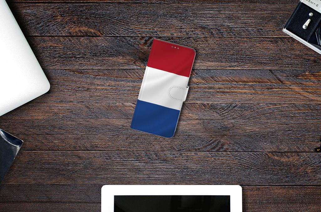Motorola Moto G9 Plus Bookstyle Case Nederlandse Vlag op houten tafel met andere gadgets.
