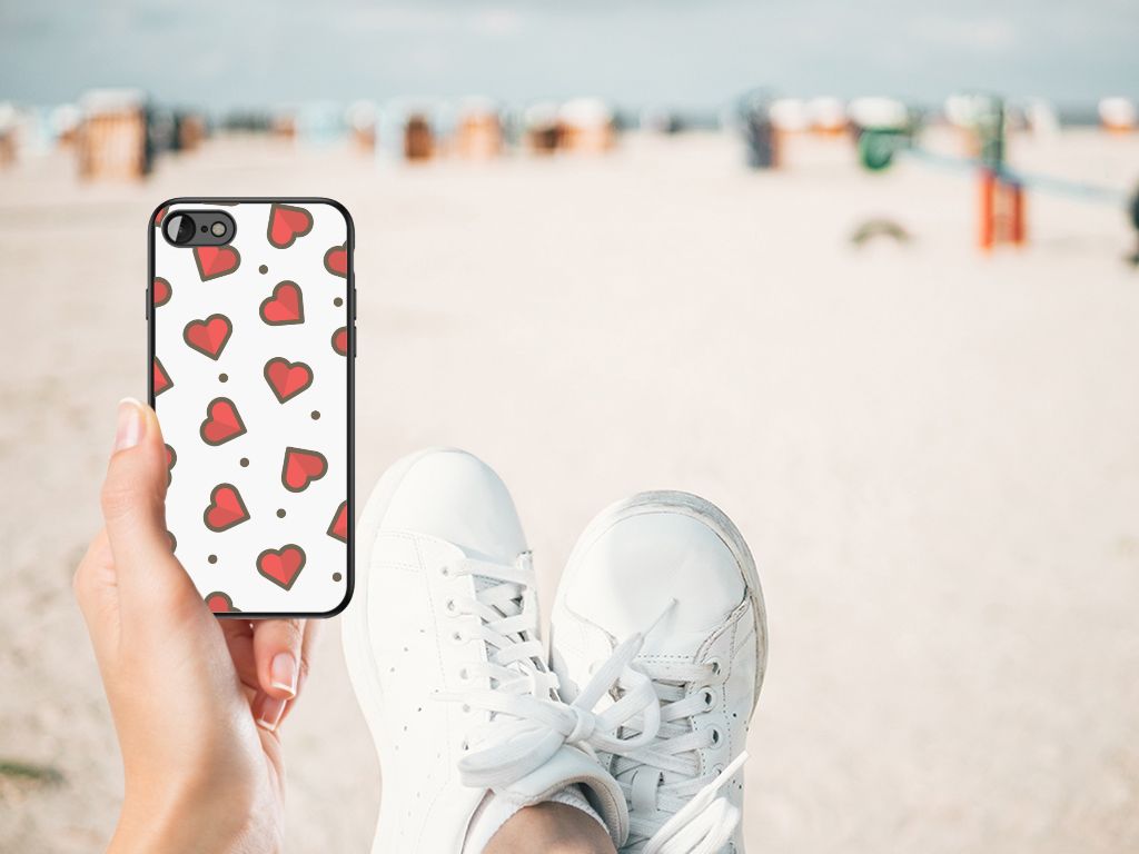 iPhone SE 2022 | SE 2020 | 7/8 Back Case Hearts displayed on a beach with a person's feet in white sneakers.