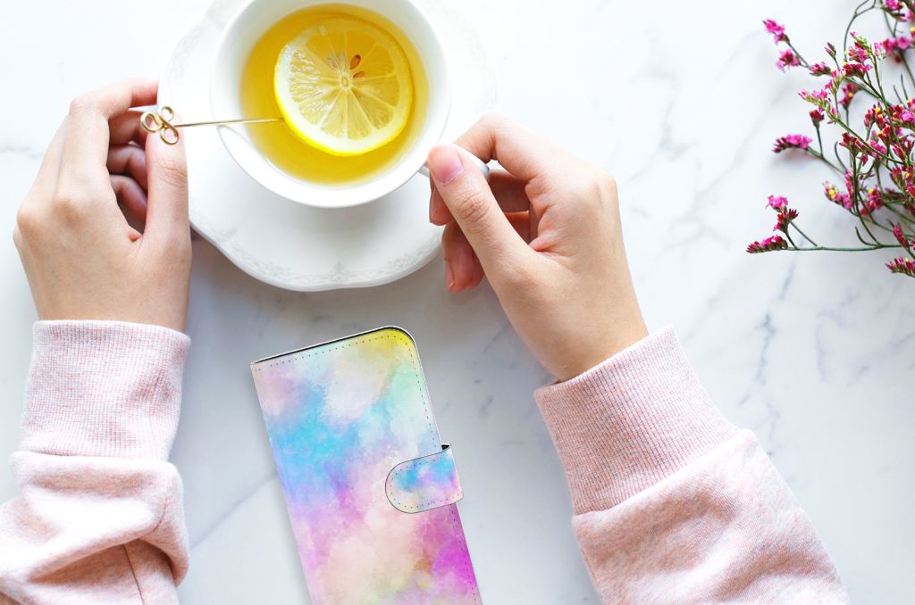Hoesje iPhone 15 Watercolor Light met pastel kleuren naast een kopje thee met citroen.