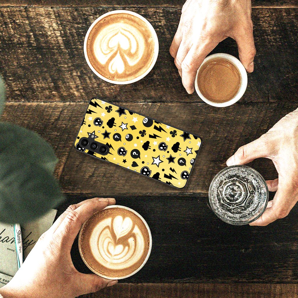 Telefoonhoesje Samsung Galaxy A14 5G Punk Geel met skulls print op een houten tafel met koffie.