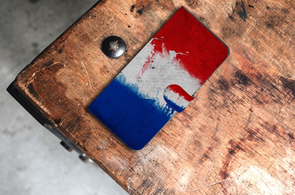 Samsung Galaxy Xcover 7 Bookstyle Case Nederland op een houten tafel met artistiek design in rood, wit en blauw.