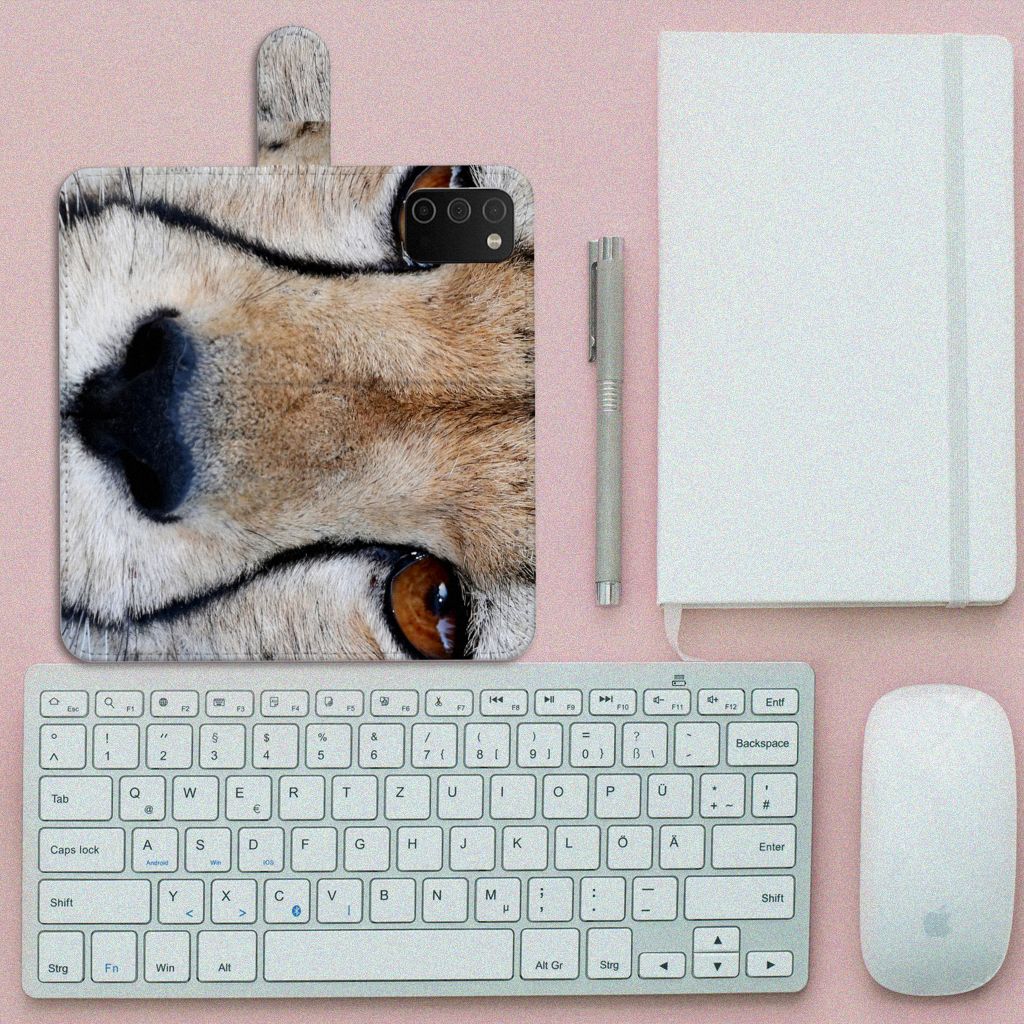 Samsung Galaxy A03s Telefoonhoesje met Pasjes Cheetah close-up op een bureau met toetsenbord en notitieboek.