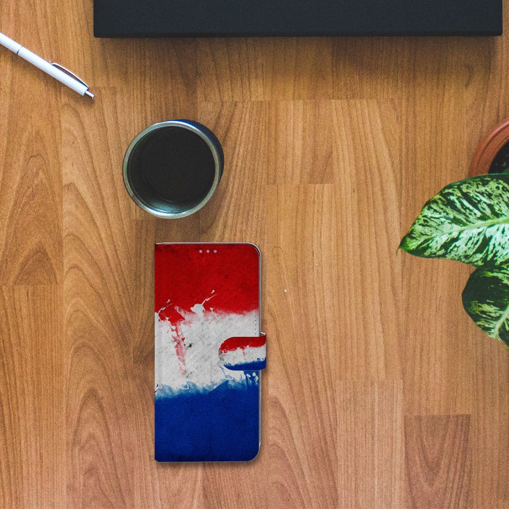OnePlus 8T Bookstyle Case Nederland met Nederlandse vlagdesign op houten tafel met planten.