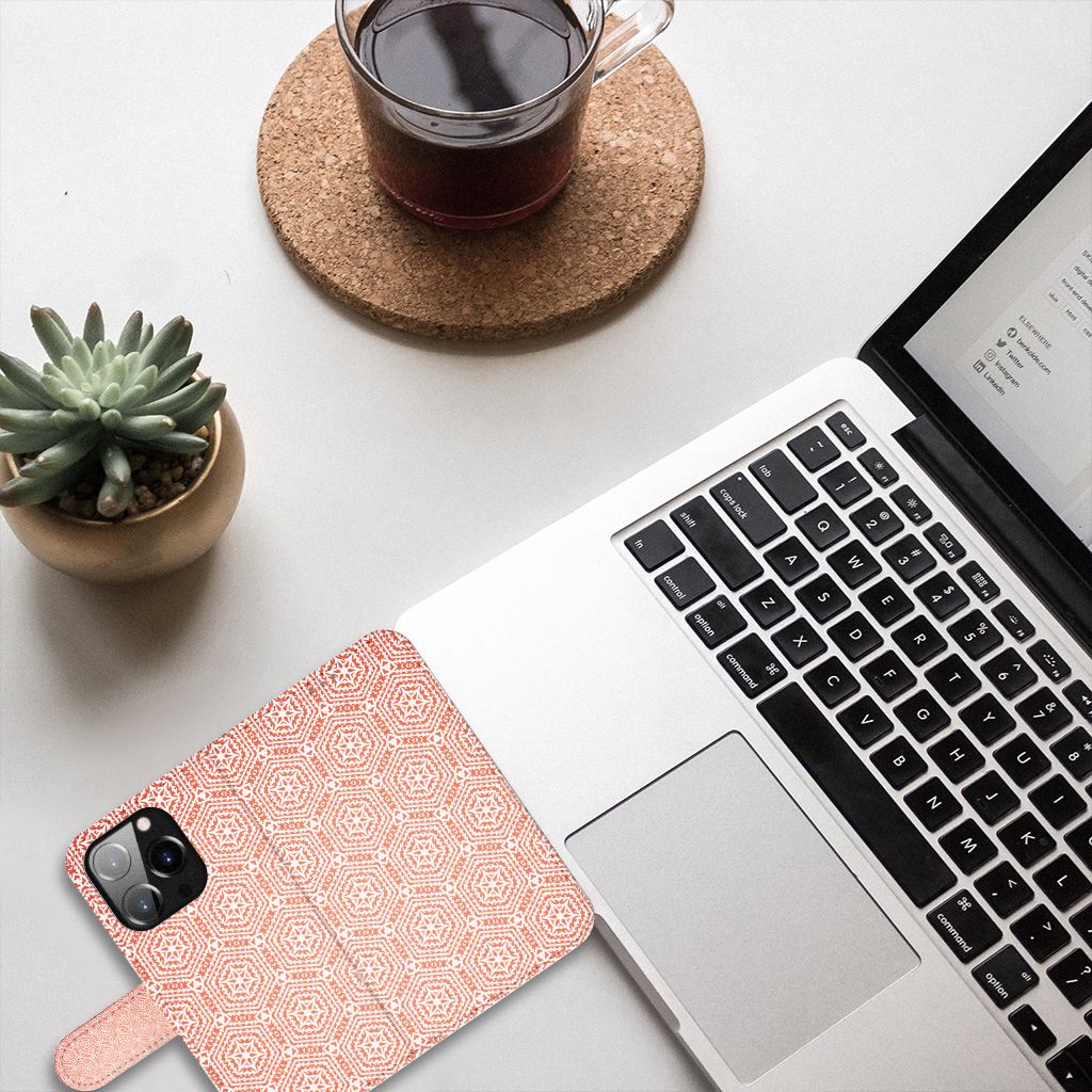 iPhone 14 Pro Telefoon Hoesje Pattern Orange naast een laptop met een kopje koffie.