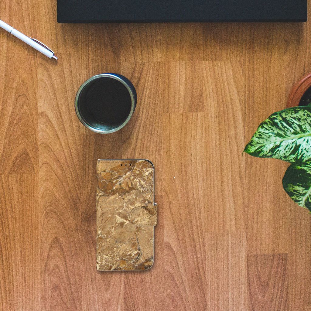 iPhone 13 Mini Bookcase Marmer Creme op een houten tafel met een kopje en een plant