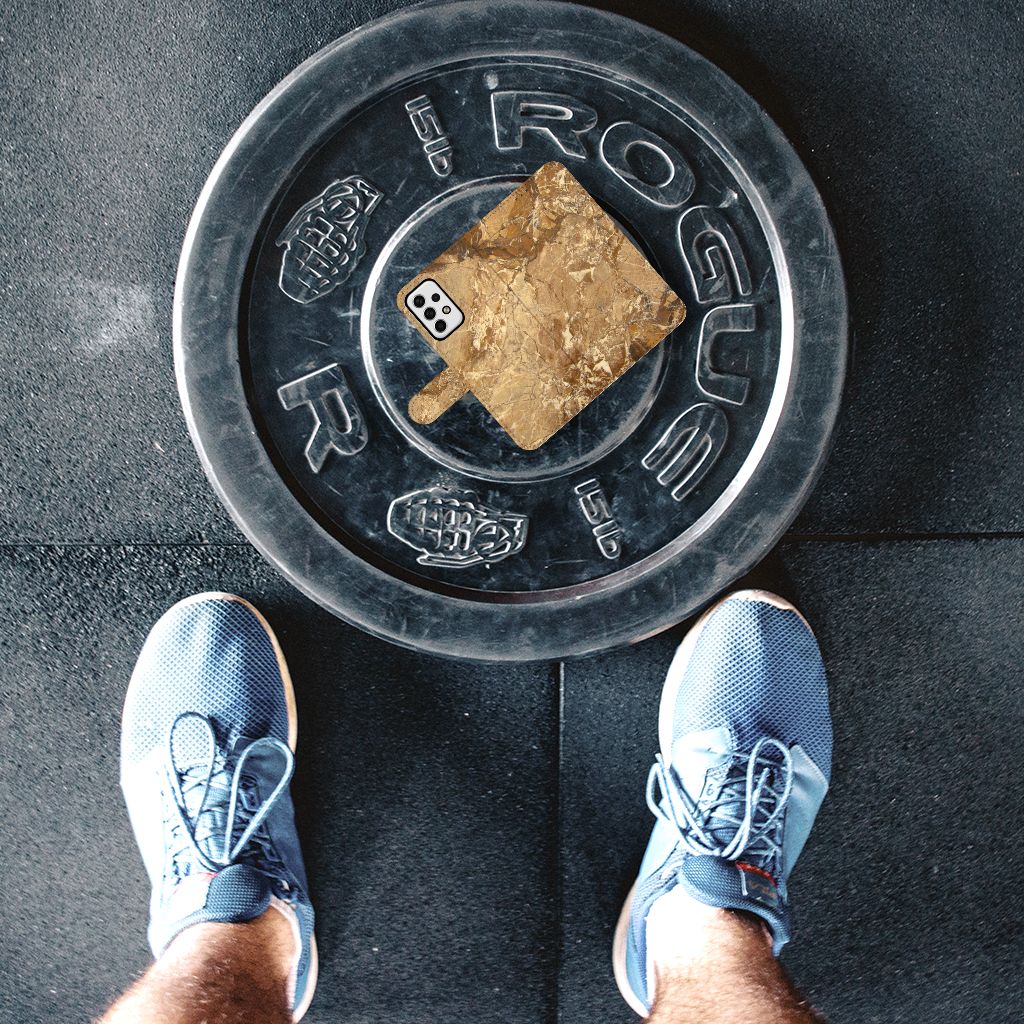 Persoon met blauwe schoenen staat boven een Rogue gewichtsschijf met een goudkleurig object erop.