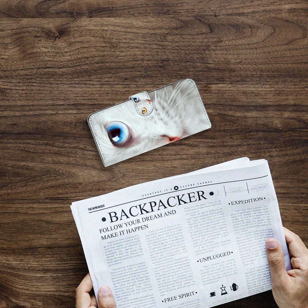 Samsung Galaxy A14 4G Telefoonhoesje met Pasjes Witte Kat op een houten tafel met een krant ernaast.