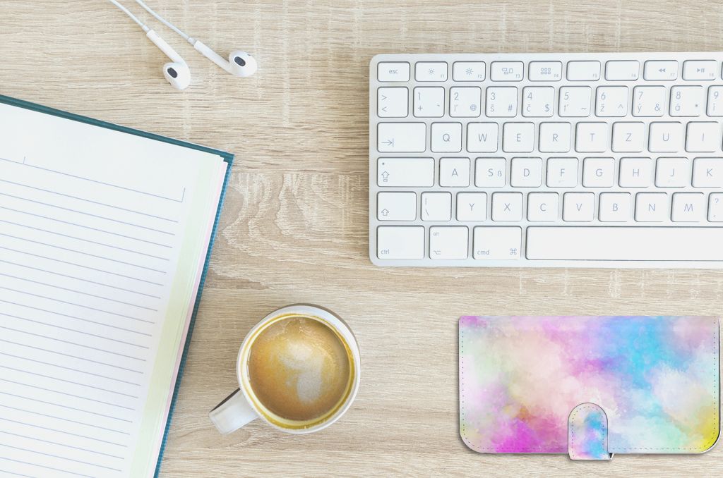 Hoesje iPhone 15 Plus Watercolor Light met pastelkleuren op bureau met notitieboek en kop koffie.