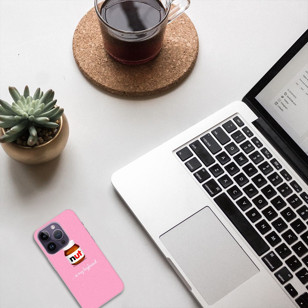 Apple iPhone 14 Pro Siliconen Case Nut Boyfriend op een bureau met laptop en plantaardig decor.