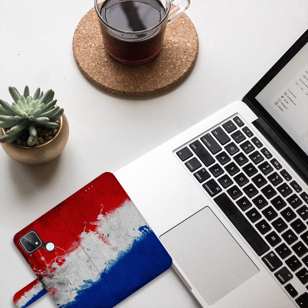 OPPO A15 Bookstyle Case Nederland met Nederlandse vlag, geplaatst op een bureau naast een laptop en plant.