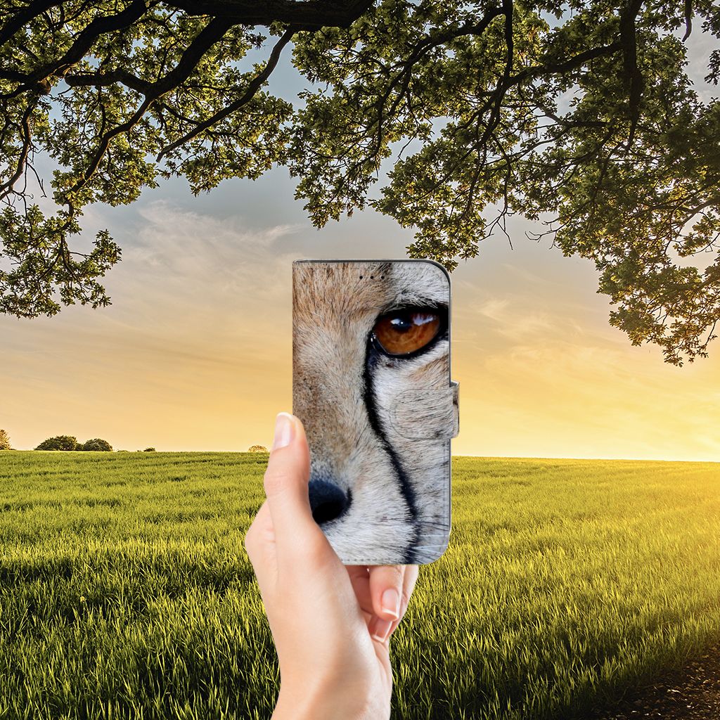 Apple iPhone 13 Telefoonhoesje met Pasjes Cheetah in hand, met detail van cheeta oog en natuurdecor.