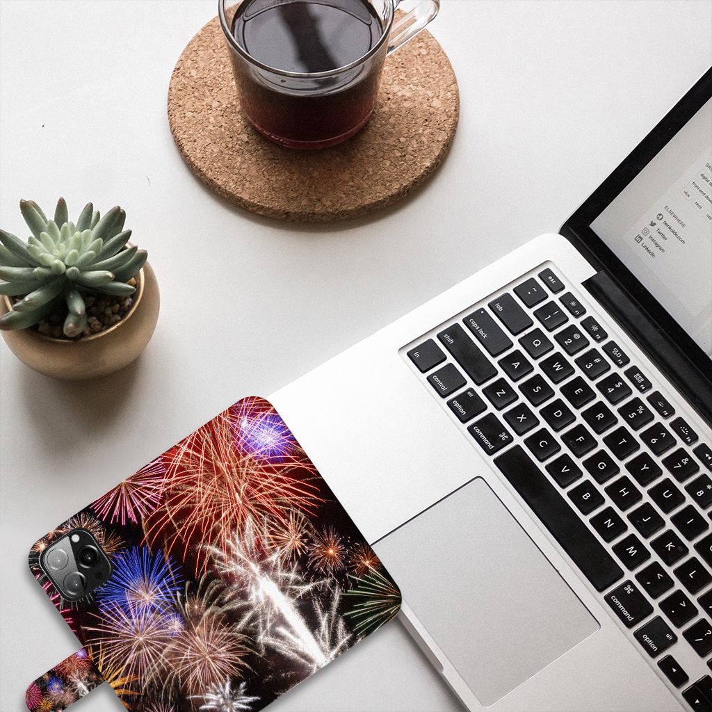 iPhone 13 Pro Max Wallet Case met Pasjes Vuurwerk met kleurrijke vuurwerkprint op een bureau met laptop en koffie.
