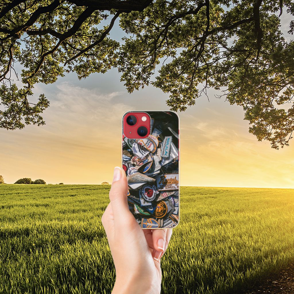 Apple iPhone 13 Siliconen Hoesje met foto Badges, met kleurrijke badges in een hand, tegen een zonnige achtergrond.