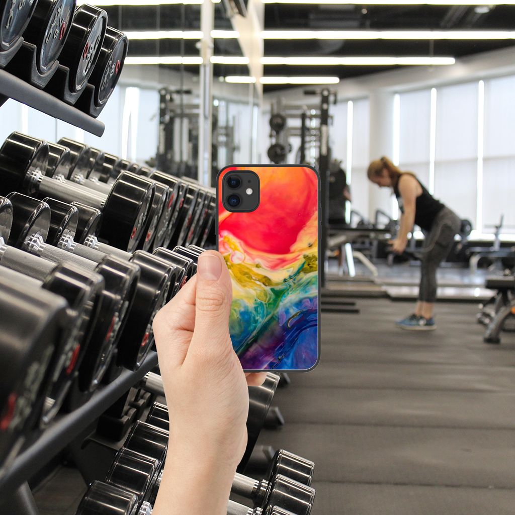 Kleurrijke Telefoonhoesje iPhone 11 Watercolor Dark in gebruik in een sportschool met gewichten.