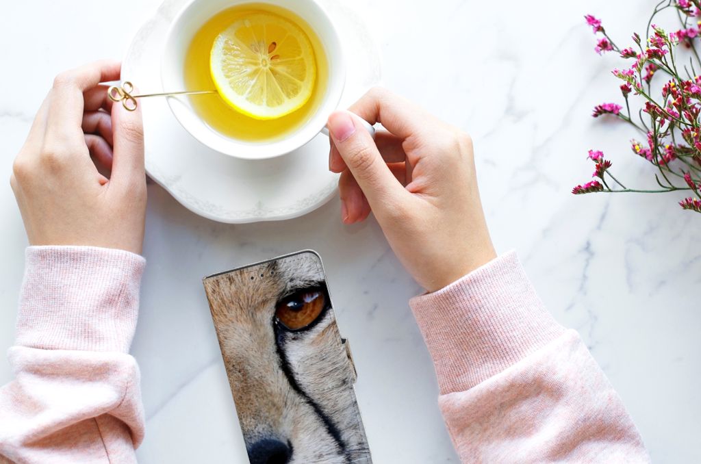 Huawei P40 Telefoonhoesje met Pasjes Cheetah met close-up van cheeta en hand die een kopje thee vasthoudt.