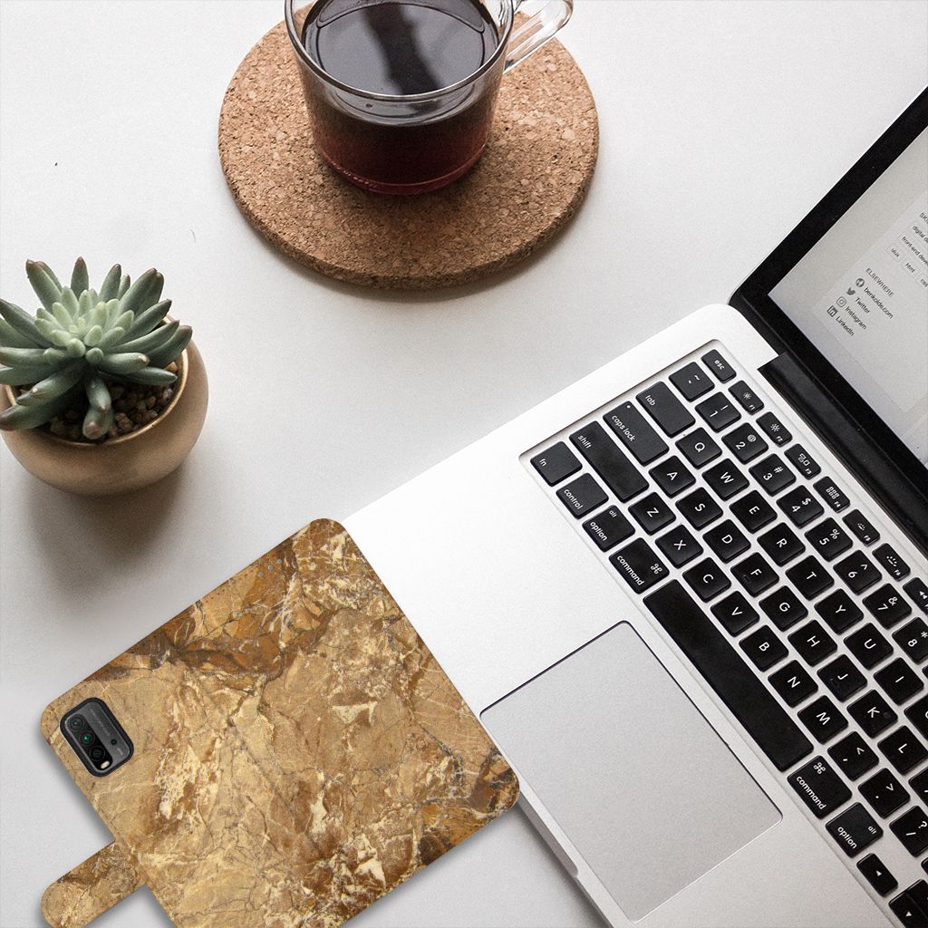 Xiaomi Redmi 9T | Poco M3 Bookcase Marmer Creme op een bureau naast een laptop en een plant.