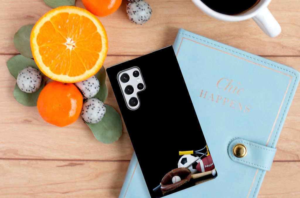 Samsung Galaxy S22 Ultra Hippe Standcase Sports with sports images on a wooden table next to fruits and a notebook.