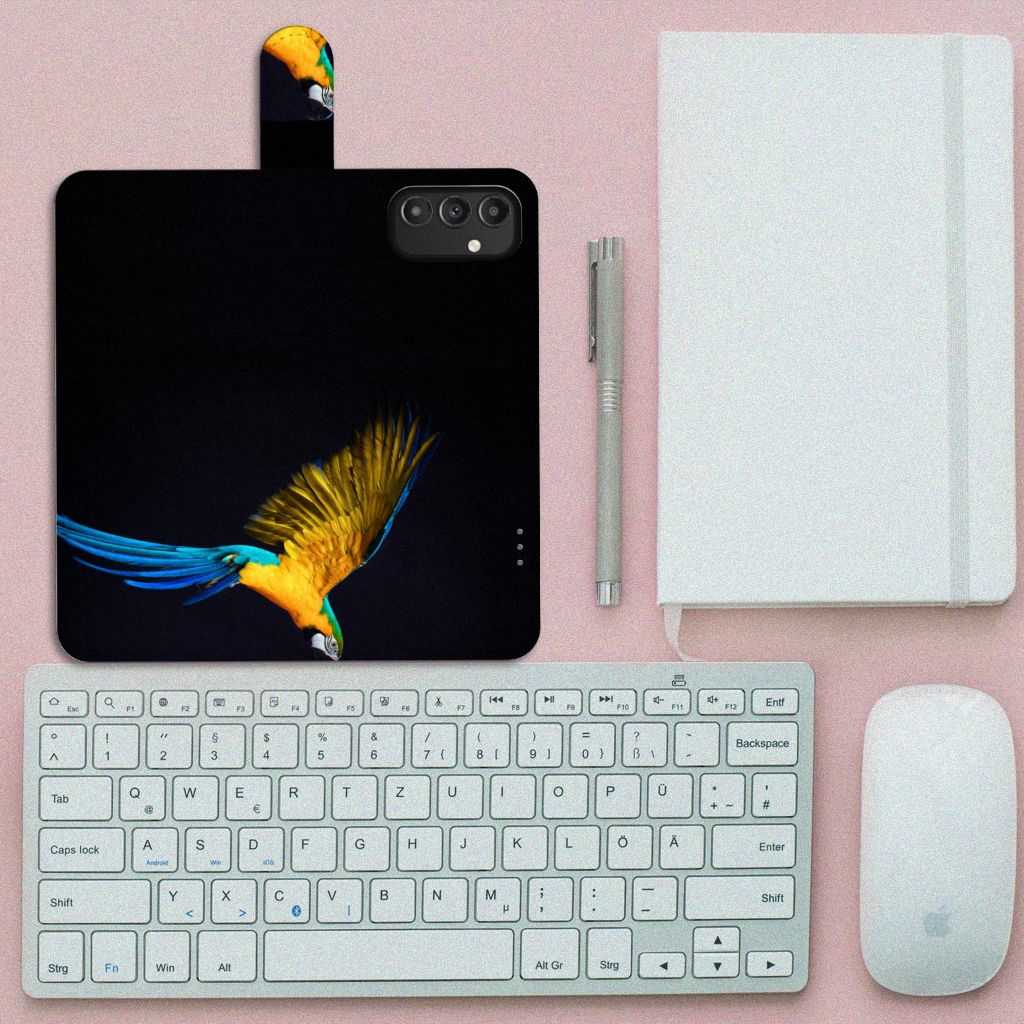 Samsung Galaxy A14 5G Telefoonhoesje met Pasjes Papegaai op een bureau met toetsenbord, muis en notitieboekje.