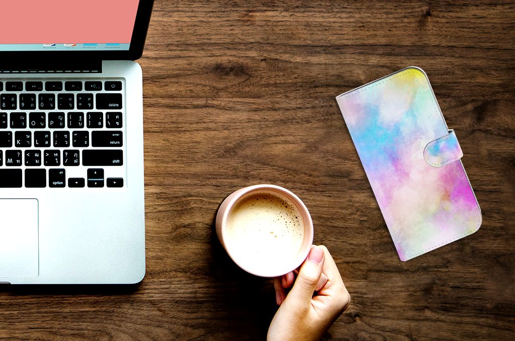 Hoesje iPhone 15 Pro Max Watercolor Light naast laptop en kop koffie op een houten tafel.