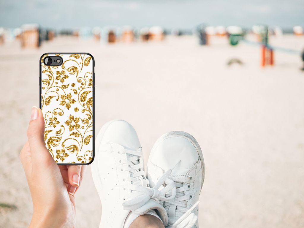 iPhone SE 2022 | SE 2020 | 7/8 Bloemen Hoesje Gouden Bloemen op een hand met sneakers op het strand.