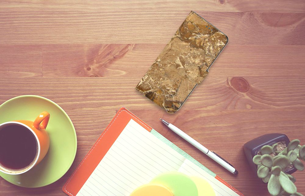 OnePlus Nord N10 Bookcase Marmer Creme op een bureau met koffie, notitieboek en planten.