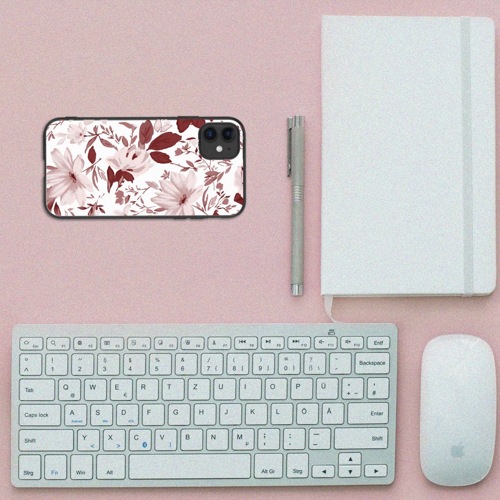 Kleurrijke Telefoonhoesje iPhone 11 Watercolor Flowers met bloemenprint op een bureau met toetsenbord en notitieboek.