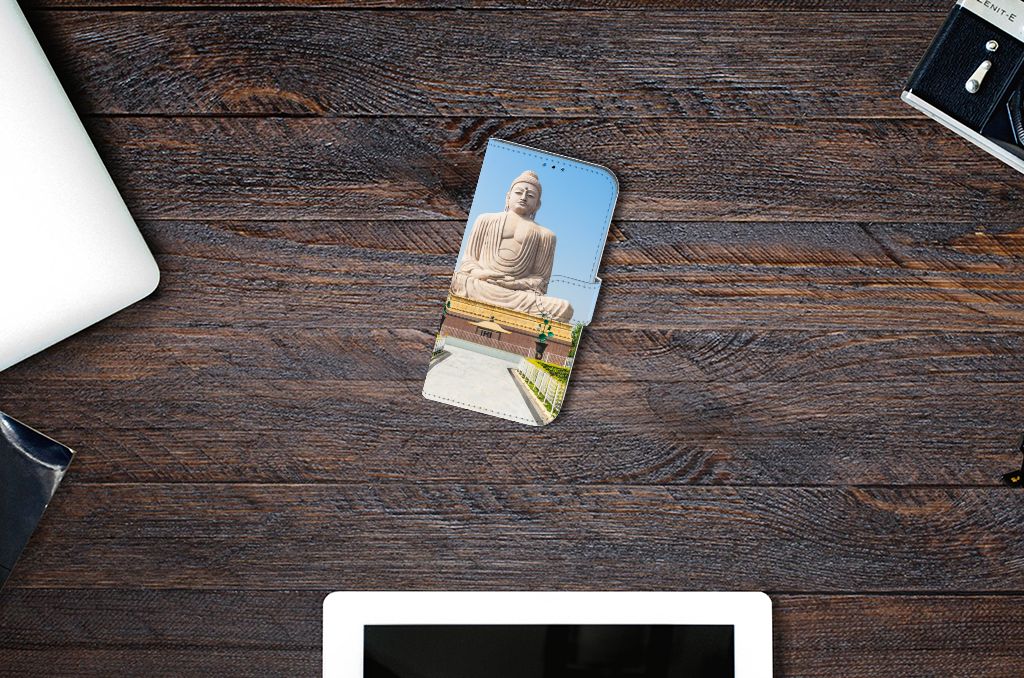 iPhone 14 Pro Flip Cover Boeddha met Boeddhabeeld voor ontspanning en geluk op houten tafel.