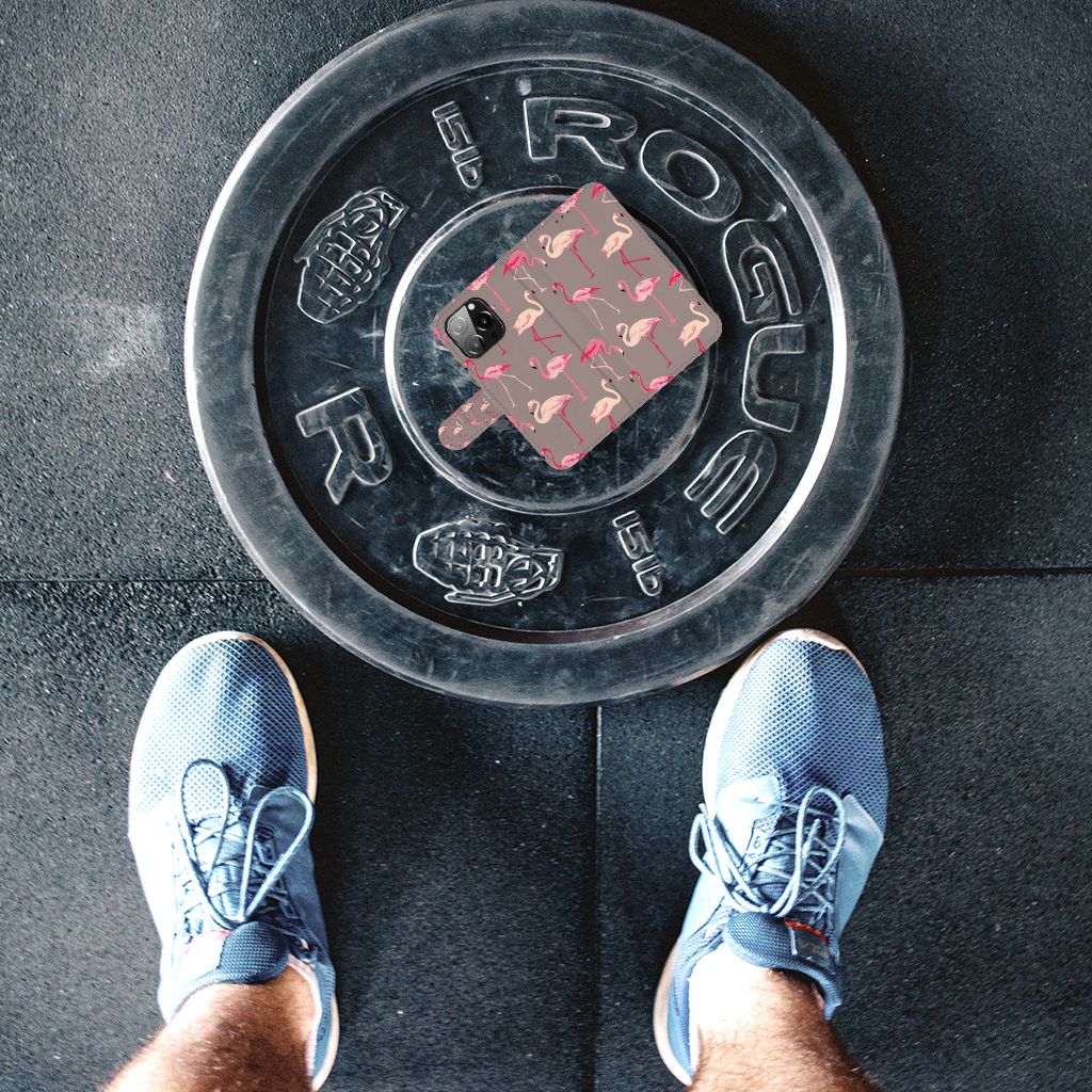 iPhone 13 Pro Telefoonhoesje met Pasjes Flamingo ligt op een gewichtsschijf in de sportschool.