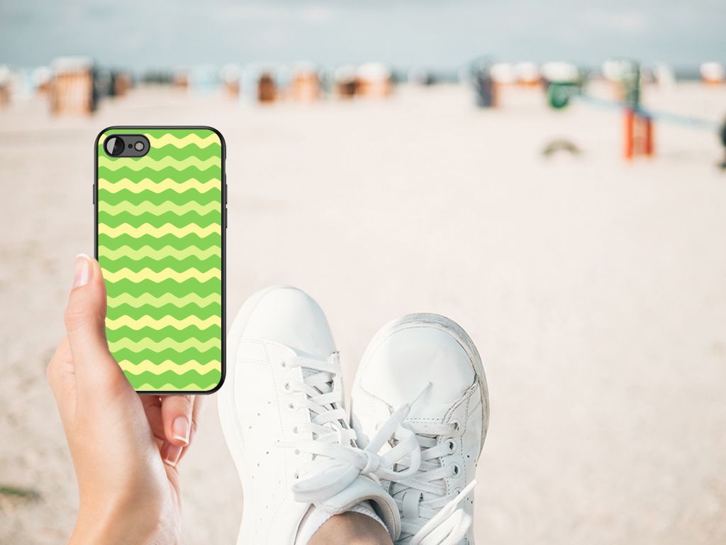 iPhone SE 2022 | SE 2020 | 7/8 Back Case Waves Green held by a person on the beach with sneakers visible.