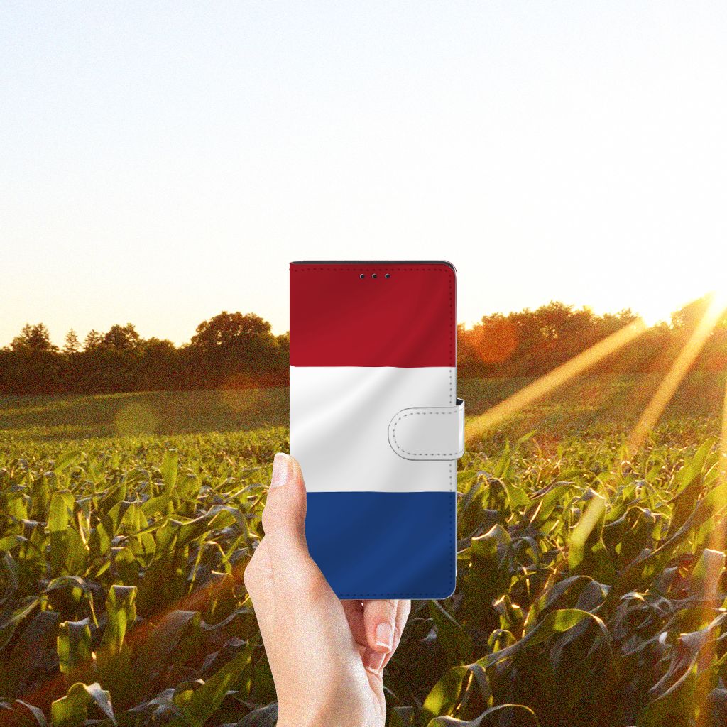Motorola Edge 20 Lite Bookstyle Case Nederlandse Vlag in een hand met zonsondergang en maïsveld op de achtergrond