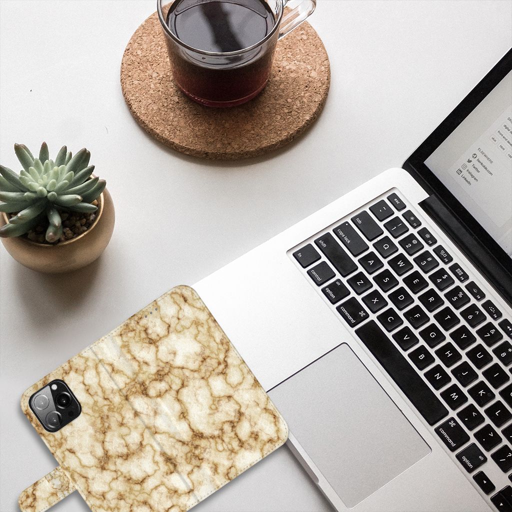 iPhone 13 Pro Max Bookcase Marmer Goud met marmerdesign op bureau met laptop en een blikje koffie.