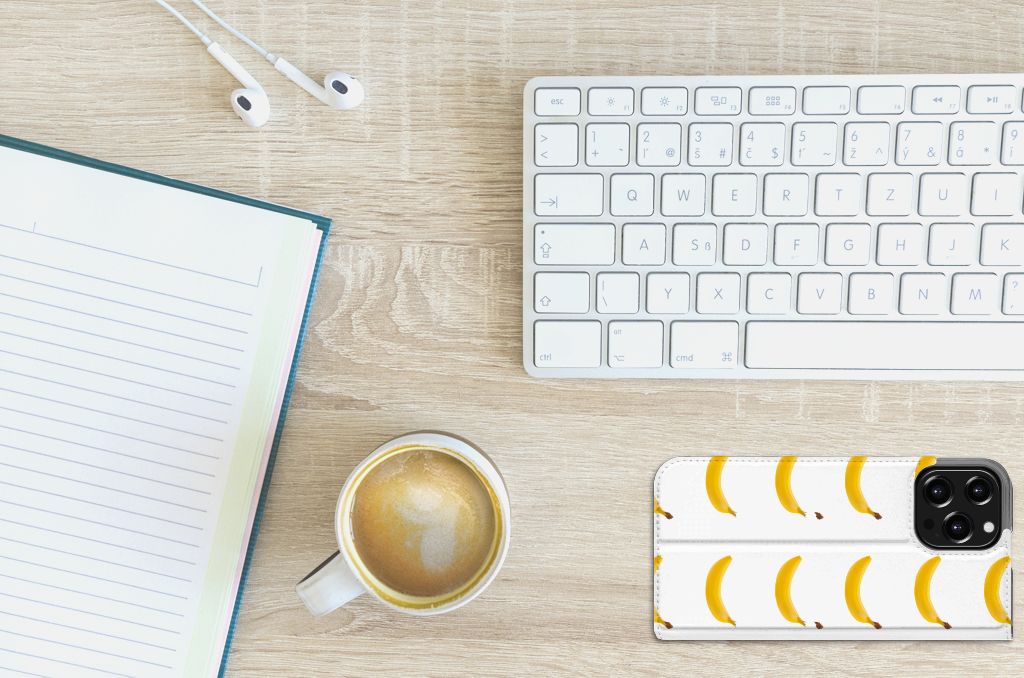 iPhone 13 Pro Max Flip Style Cover Banana met een design van bananen, gelegen naast een notitieboek, toetsenbord en koffie ☕.