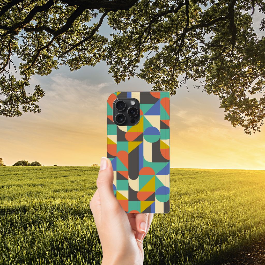iPhone 15 Pro Max Hoesje met Magneet Funky Retro in kleurrijk design, vastgehouden tegen een natuurlijke achtergrond.