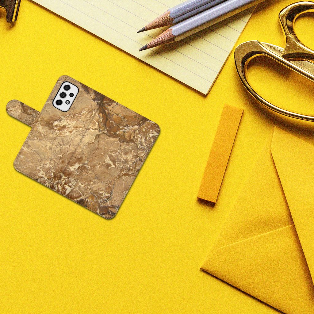 Samsung Galaxy A53 Bookcase Marmer Creme op een gele achtergrond met kantoorbenodigdheden.
