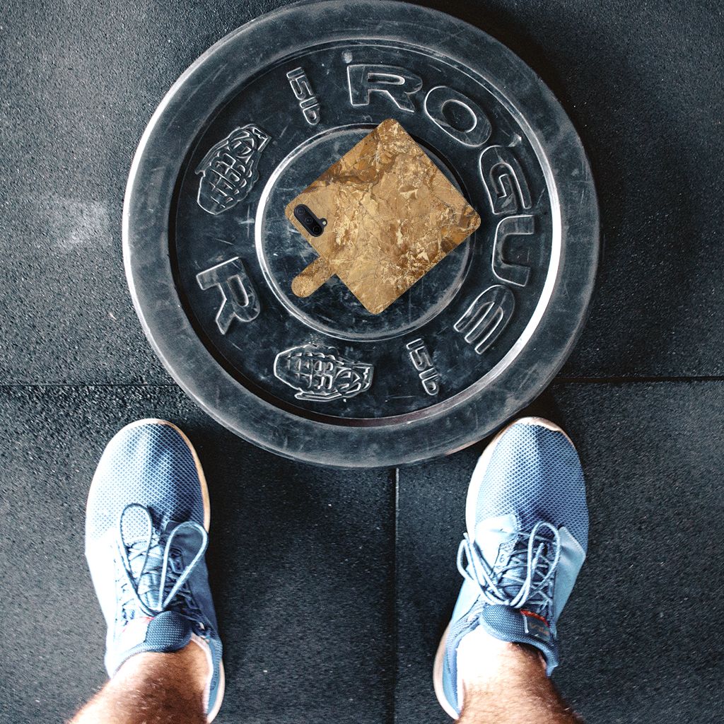 OnePlus Nord CE 5G Bookcase Marmer Creme op een gewichtsschijf met sportschoenen eromheen.