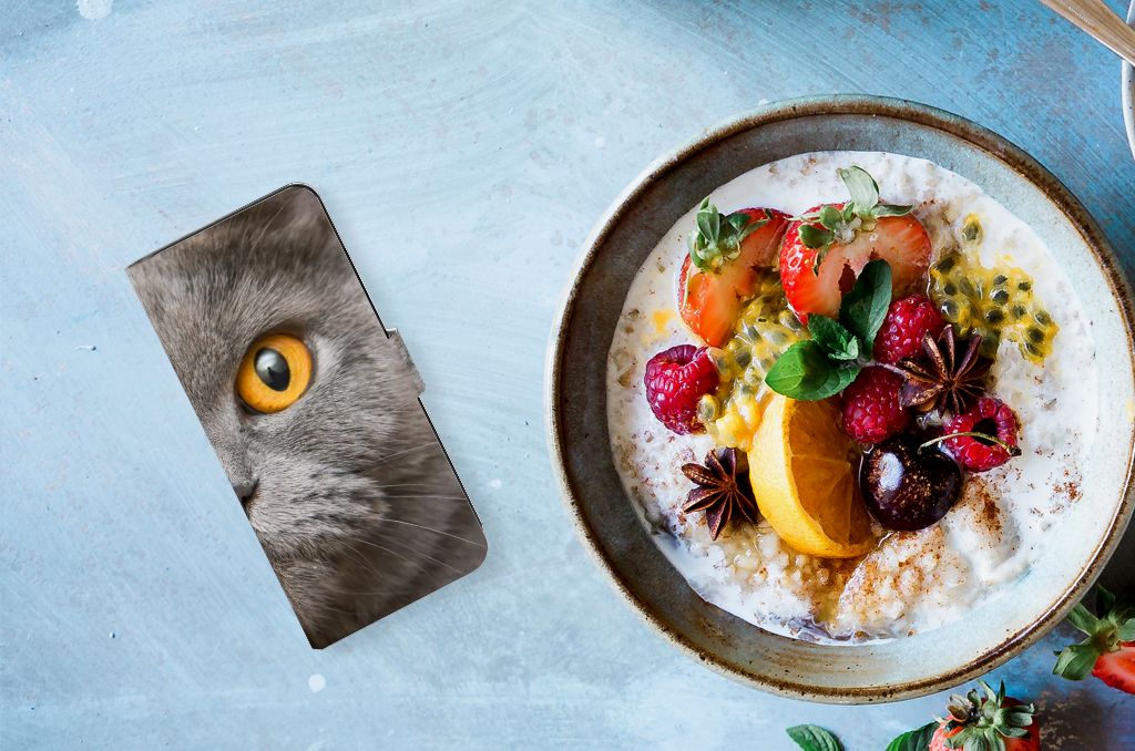 Telefoonhoesje met Pasjes Samsung Galaxy M54 Britse Korthaar naast een kom met fruit en yoghurt.