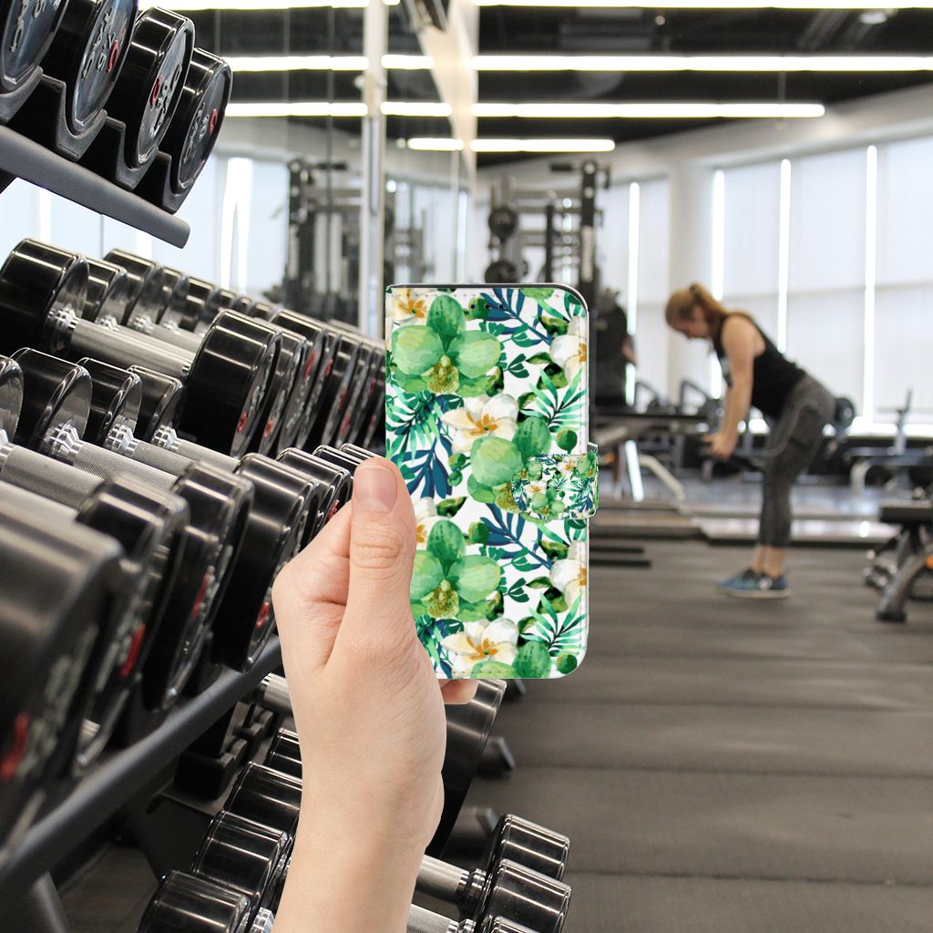 iPhone 13 Pro Hoesje Orchidee Groen in hand, tropisch design met groene bladeren en bloemen in sportschoolomgeving.