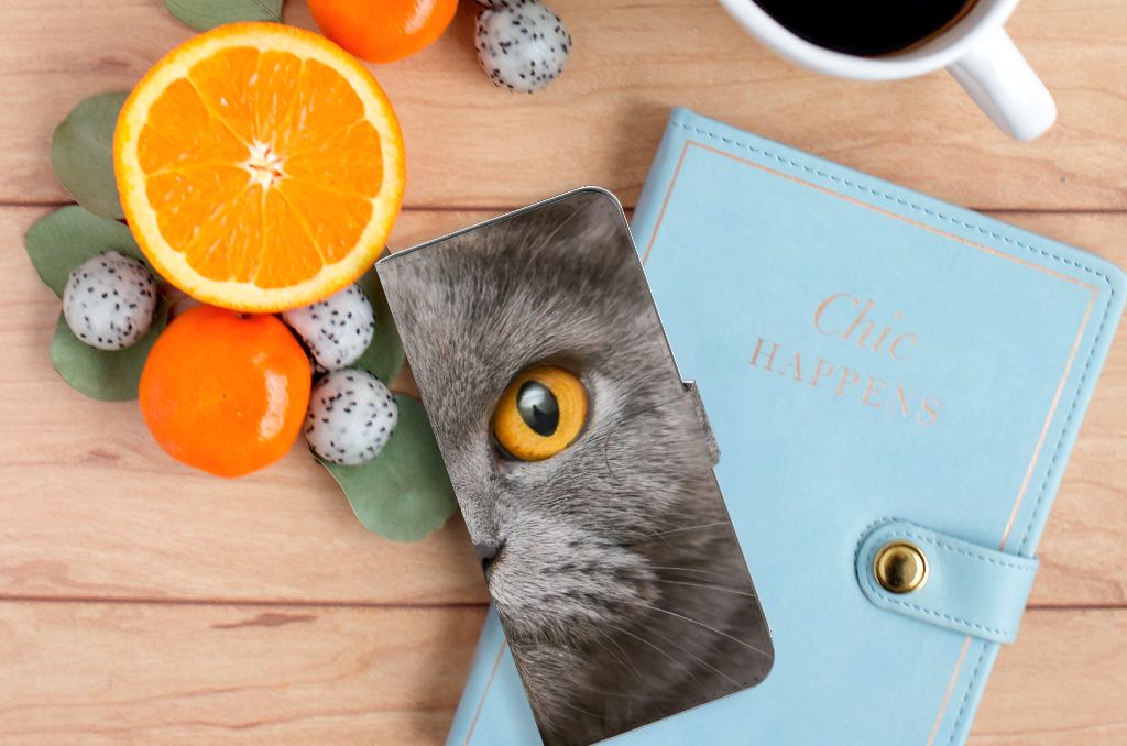 Telefoonhoesje met Pasjes OPPO A58 4G Britse Korthaar op een houten tafel met citrusvruchten en een notitieboekje.