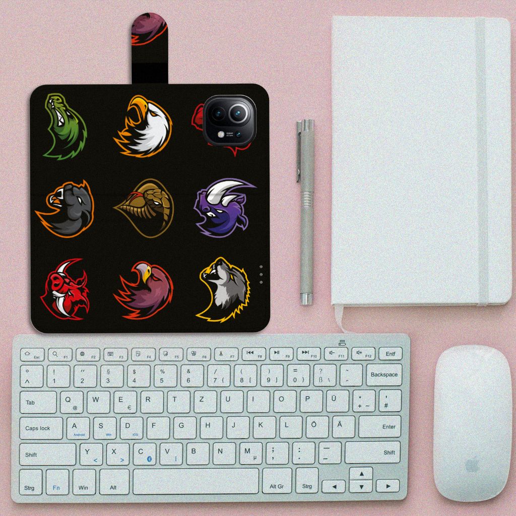 Xiaomi Mi 11 Leuk Hoesje Cartoon met kleurrijke dierenkoppen op zwart design, naast toetsenbord en notitieboek.