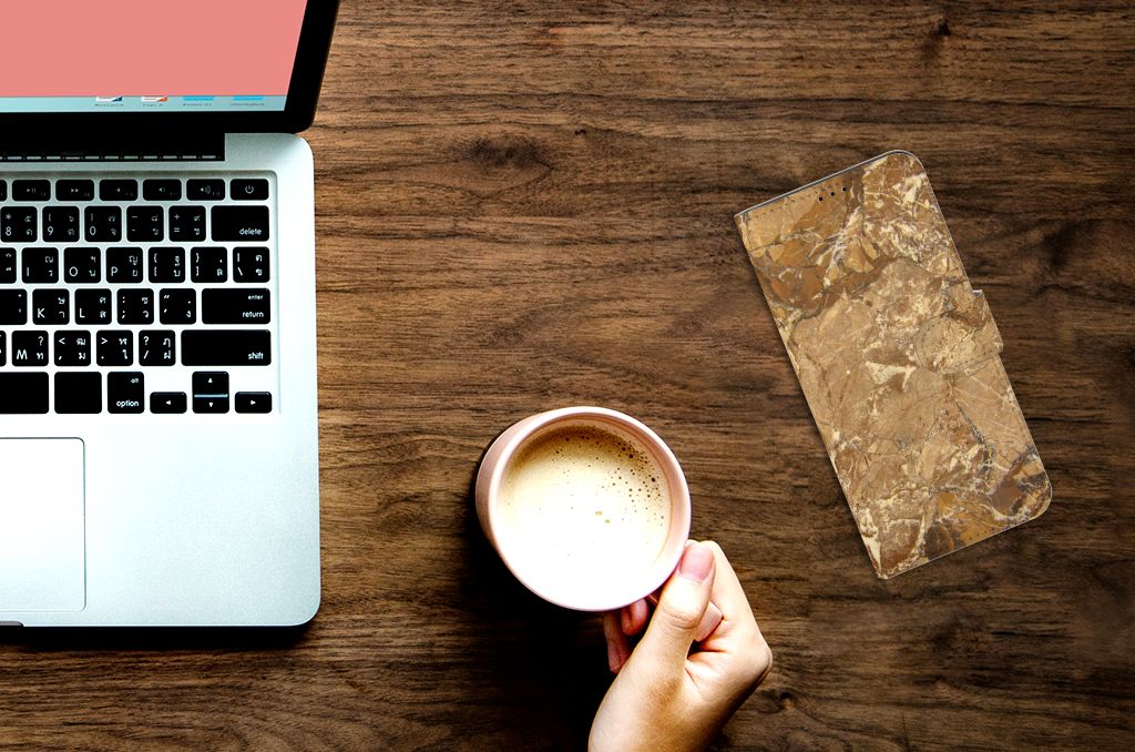 Sony Xperia 1 III Bookcase Marmer Creme naast een laptop en een kop koffie op een houten tafel.