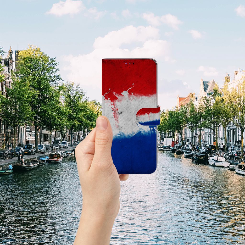 Samsung Galaxy A22 5G Bookstyle Case Nederland met artistiek ontwerp van de Nederlandse vlag in hand bij een kanaal.