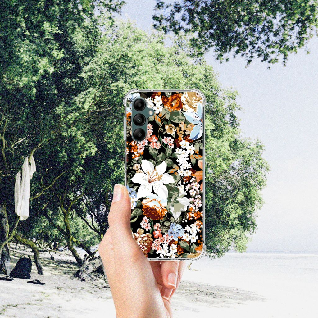 Case voor Samsung Galaxy A14 5G/4G Dark Flowers met kleurrijk bloemenontwerp gehouden in hand op het strand.